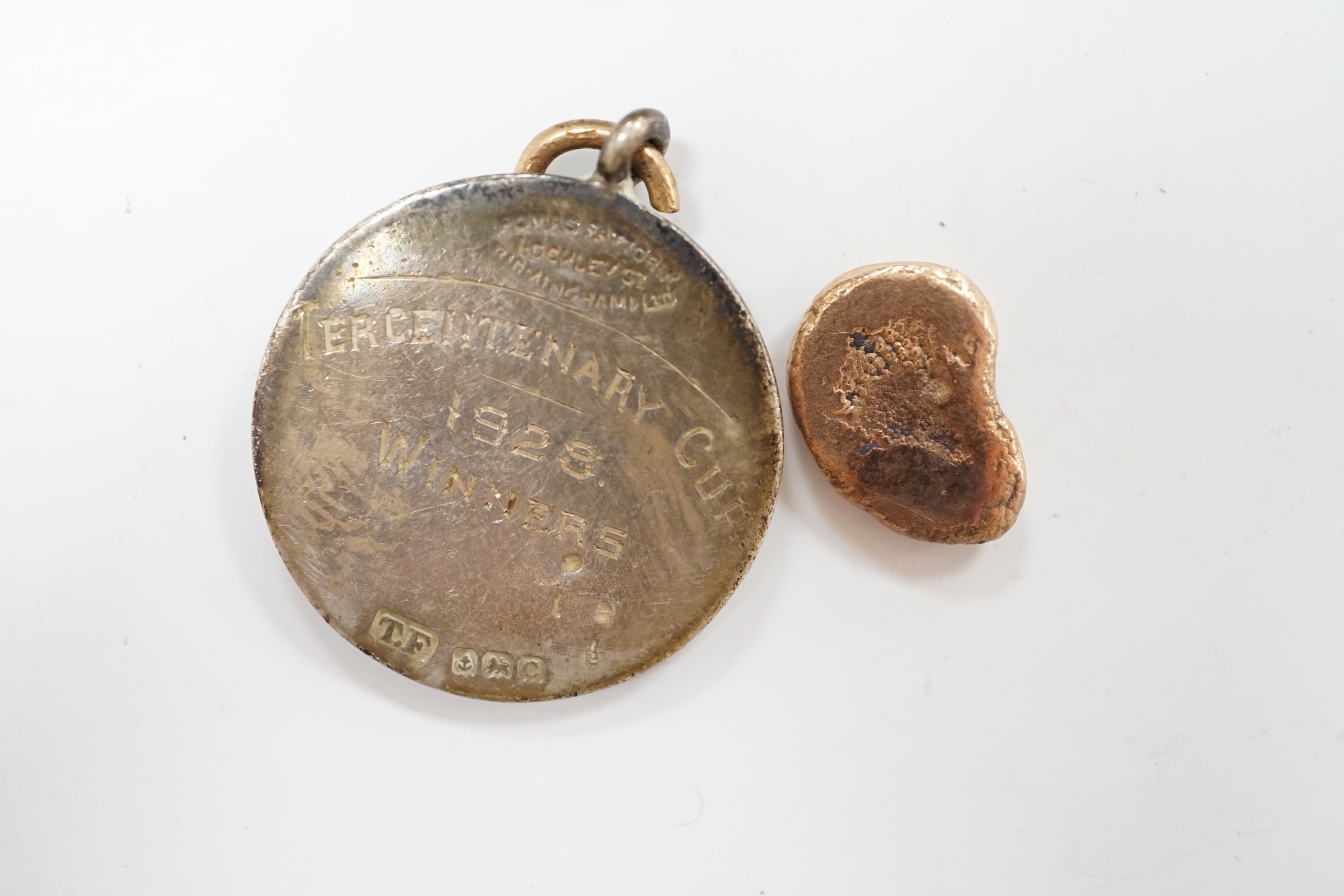 A silver charm bracelet, hung with assorted mainly white metal charms including tankard and Knight's helmet, two 'melted' ingots and a silver medallion.